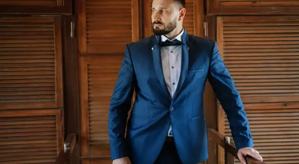 Elegancki mężczyzna w granatowym garniturze, idealny wybór, jaki kolor garnituru na wesele.