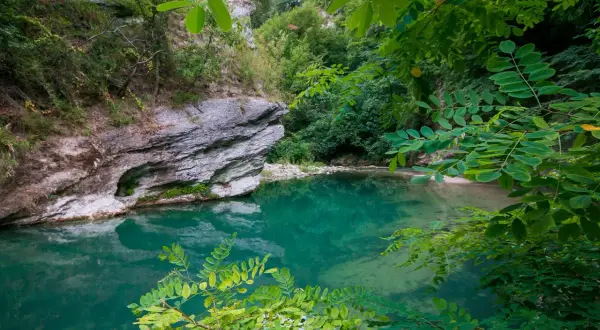 Acque cristalline e rocce imponenti in un angolo di paradiso naturale, un luogo che ricorda la purezza delle terme di Acquasanta.