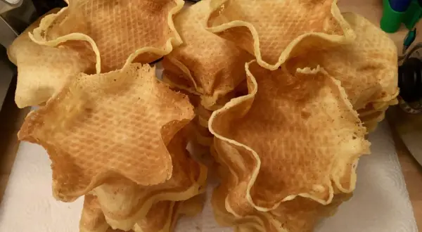 Frisch gebackene, sternförmige Eiswaffeln liegen gestapelt auf Küchenpapier. Perfekt zum **eiswaffeln selber machen** für den Sommer!