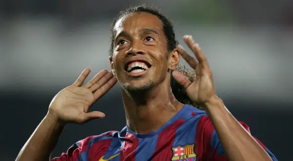 Uśmiechnięty Ronaldinho w koszulce Barcelony, z dłońmi przy uszach, jakby słuchał dopingu. Tak, Ronaldinho żyje i wciąż zachwyca!
