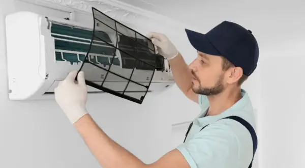 Tecnico rimuove filtro per sanificazione condizionatori. Scopri il prezzo per un'aria più pulita.