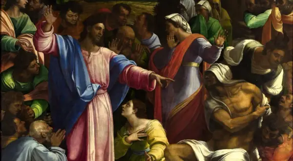 Jezus wskazuje na wskrzeszanego Łazarza. Tłum ludzi patrzy z podziwem i niedowierzaniem.