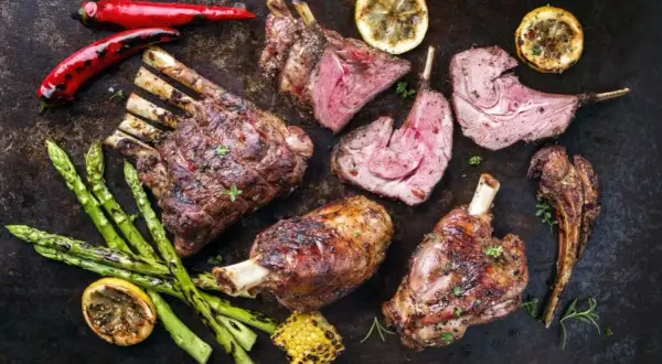 Pieczona dziczyzna z dodatkami: szparagi, cytryna, papryczki chili i kukurydza.