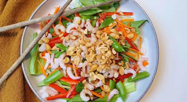 En fräsch asiatisk nudelsallad med räkor, grönsaker och jordnötter. Perfekt för en lätt lunch eller middag.