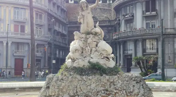 Fontana con statua di Partenope, figura mitologica legata a Ulisse, circondata da creature marine.