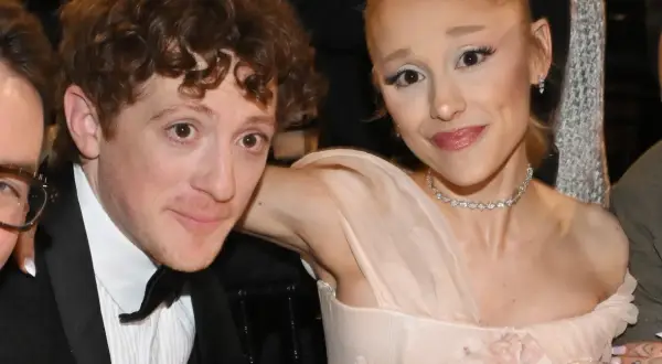 Ariana Grande z partnerem Ethanem Slaterem, uśmiechnięci, w eleganckich strojach.