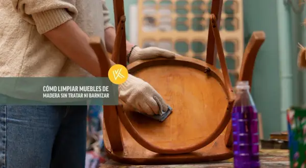 Persona con guantes limpia un mueble de madera, mostrando cómo limpiar madera sin dañar el barniz.