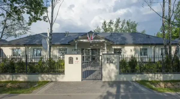 Elegancki lawendowy dom opieki seniora, z pięknym ogrodem i bramą.