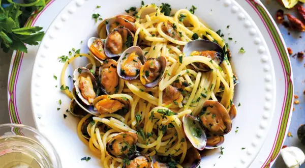 Spaghetti alle vongole cremosi come al ristorante, un piatto invitante con pasta, vongole e prezzemolo fresco.