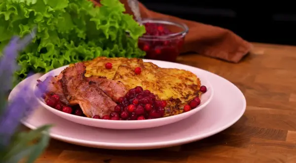 Rökt sidfläsk med stekt potatis och lingon, en härlig bit av traditionell svensk mat.