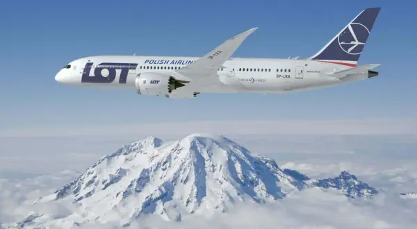 Dreamliner 787 LOT Polish Airlines przelatuje nad ośnieżonymi szczytami gór.