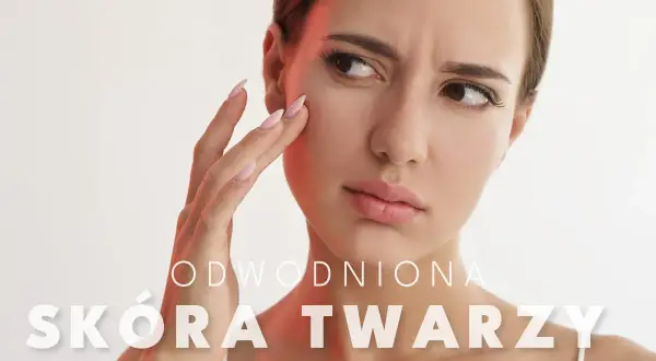 Kobieta zmartwiona stanem swojej odwodnionej skóry twarzy, dotyka policzka.