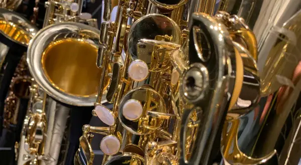 Glänzende, goldene Saxophone im Detail. Verschiedene saxophon arten sind zu sehen, mit ihren Klappen und dem Schallstück.