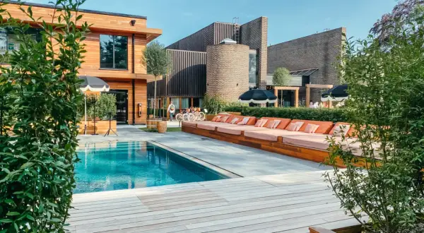 En avkopplande dag vid poolen på Ellery Beach. Solstolar i orange, parasoller och en klarblå pool.