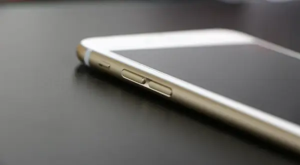 Złoty iPhone na ciemnym tle. Dowiedz się, jak znaleźć iPhone bez iCloud, gdy zgubisz urządzenie.