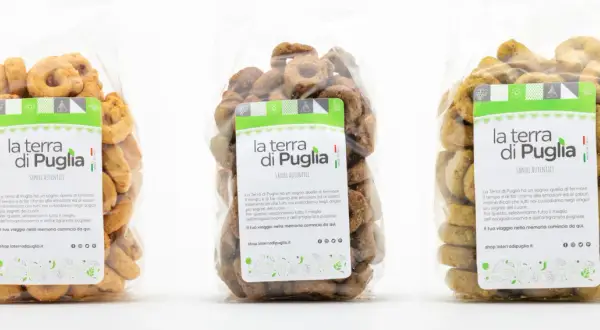Tre sacchetti trasparenti pieni di taralli salati pugliesi, con etichette che celebrano i sapori autentici della Puglia.