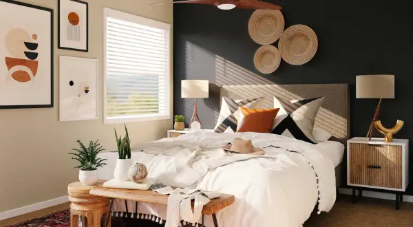 Une chambre parentale moderne avec un lit blanc, des coussins graphiques, des paniers muraux en osier et des œuvres d'art abstraites.
