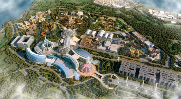 Nowoczesny park rozrywki w Londynie z futurystycznymi budynkami, kolejkami górskimi i zielonymi terenami.