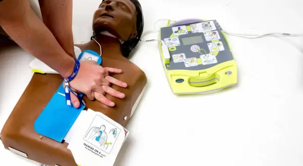 Entraînement aux gestes de premiers secours : on voit comment fonctionne un défibrillateur sur un mannequin.