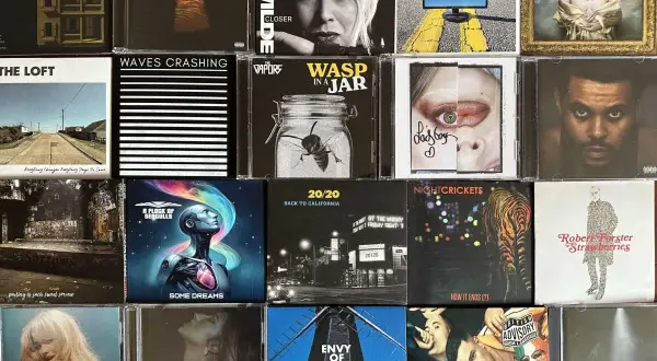 A collage of CD covers, featuring 80s artists like Kim Wilde and A Flock of Seagulls, alongside modern music.
