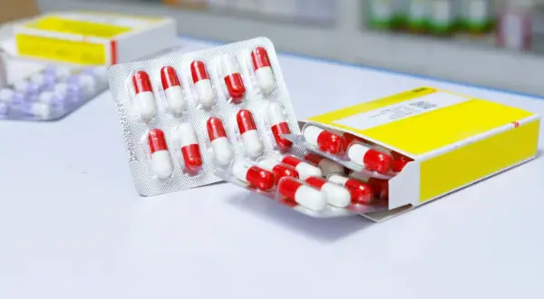 Apteczka na podróż do Egiptu: blistry z kapsułkami w kolorze czerwono-białym i fioletowo-białym.