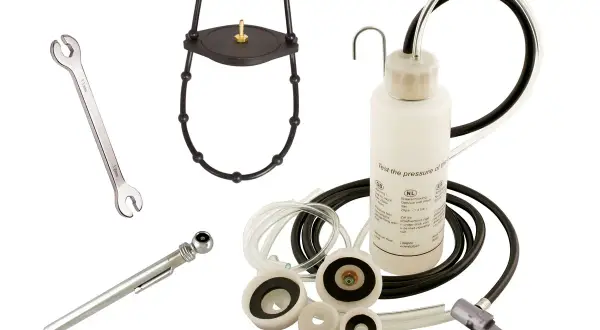 Kit pour purge embrayage hydraulique : clé, manomètre, adaptateurs et flacon de test de pression.