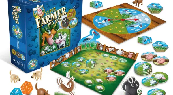 Pudełko gry Super Farmer Big Box, plansza z kołem losu, zagroda z żetonami zwierząt, kostki i figurki zwierząt.