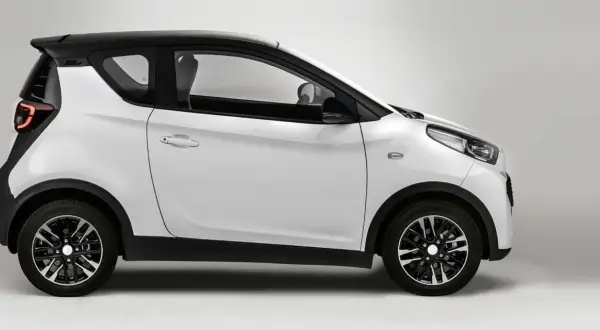 Auto elettrica bianca e nera, modello DR 1.0, vista di lato. Design moderno e compatto.
