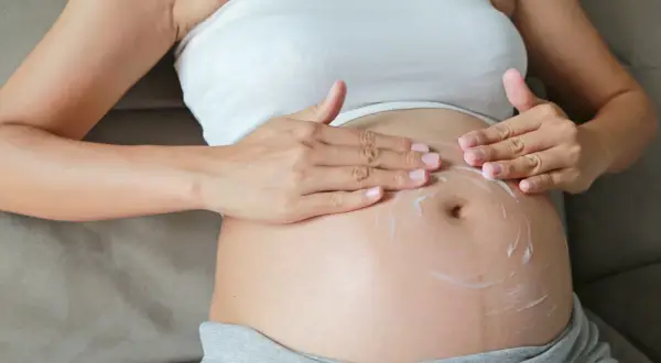 Brzuch w 24 tygodniu ciąży, który to miesiąc? Delikatne wmasowywanie kremu nawilżającego.