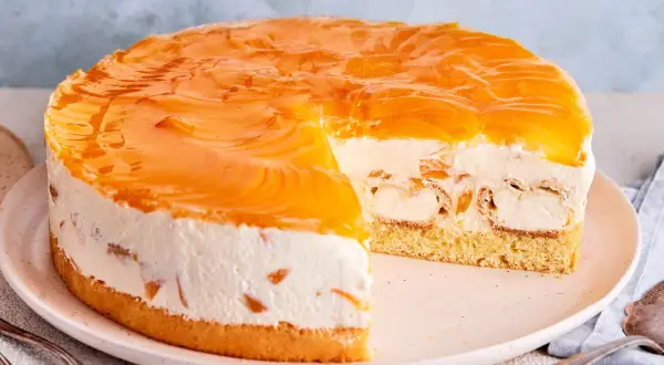 Ein köstliches Windbeuteltorte Rezept: saftiger Boden, cremige Füllung mit Windbeuteln und Pfirsichspalten, überzogen mit glänzendem Pfirsichgelee.
