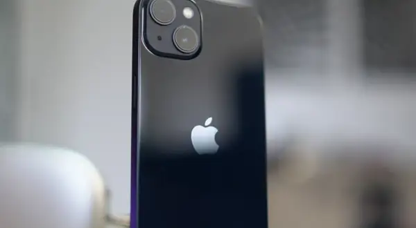 Arrière d'un iPhone 13, avec son logo Apple et le module photo incluant un objectif grand angle.