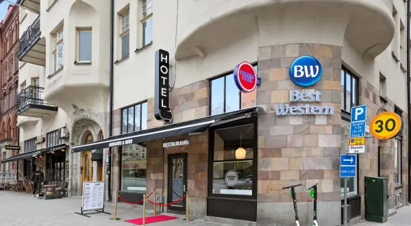 Best Western hotel vid 108, med restaurang Burgers & Beer och en taco bar. Elsparkcyklar står parkerade utanför.