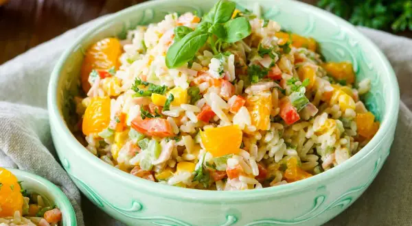 Erfrischender Reissalat mit Orangenstücken, Paprika und Kräutern. Ein leichtes und leckeres Reissalat Rezept für den Sommer.