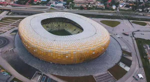 Widok z lotu ptaka na stadion w Gdańsku, z jego charakterystyczną, złotą fasadą. Idealne miejsce na zwiedzanie stadionu gdańsk i poczucie atmosfery wielkich wydarzeń sportowych.