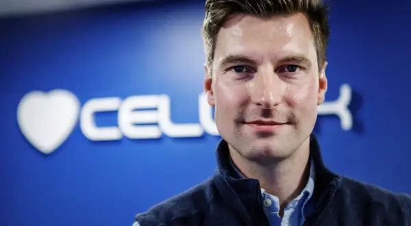 Erik Gatenholm, grundare av Cellink, ler mot kameran med en blå bakgrund med företagets logotyp.