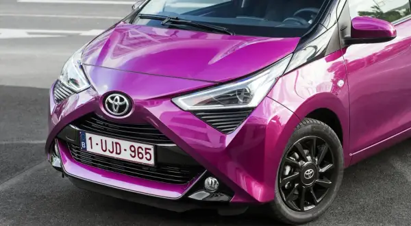 Różowy Toyota Aygo 2020 z czarnymi felgami i błyszczącym lakierem, gotowy na miejskie przygody.