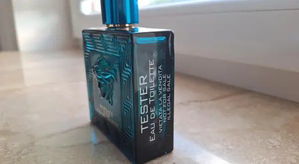 Niebieska butelka testera Versace Eros Eau de Toilette z greckim wzorem i Meduzą.