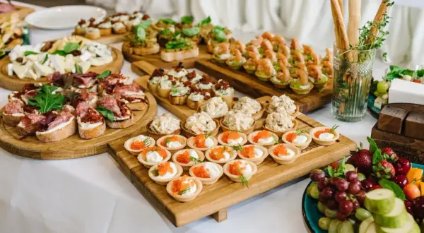 Vielfältige Snacks zum Aperitif: Bruschetta mit Salami, Käseplatte, Garnelen-Häppchen und süße Törtchen mit Kaviar.