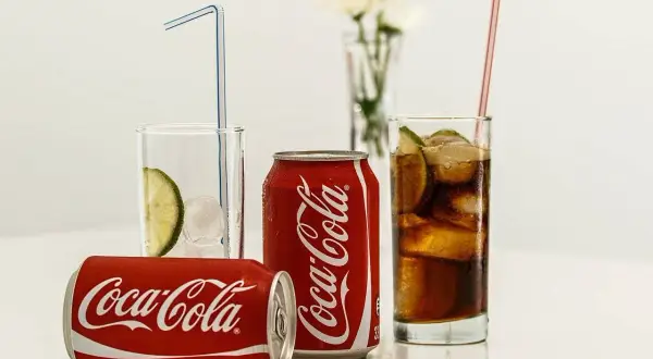 Puszki i szklanki z Coca-Colą, lodem i limonką. Zastanawiasz się, ile kalorii ma Coca-Cola?