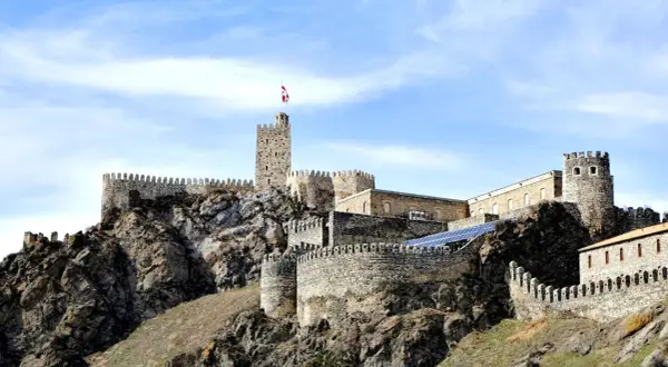 Kamienna twierdza na wzgórzu, dumnie górująca nad krajobrazem. To zamek Rabati w Achalciche, Gruzja, świadectwo historii i potęgi.
