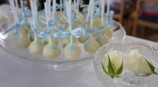 Vita cake pops med ljusblåa rosetter och blommor, perfekta för ett dop. Ett enkelt cake pops recept att prova!