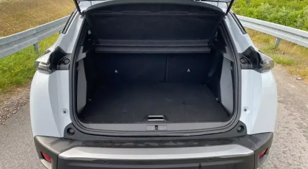 Otwarty bagażnik białego Peugeot 2008. Wymiary tego SUV-a pozwalają na wygodne pakowanie.