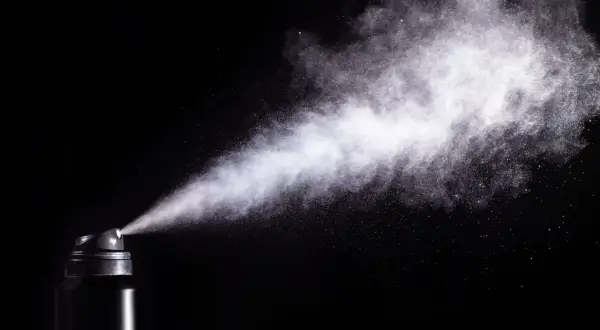 Chmura białego pyłu wydobywa się z czarnego aerozolu. Czy gaz pieprzowy działa na psy? To pytanie budzi kontrowersje.