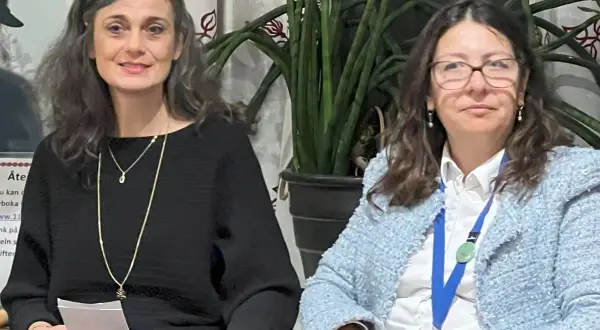 Elisabeth Punzi, till vänster, ler med glasögon på huvudet. Bredvid henne sitter en kvinna i ljusblå kavaj.