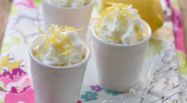 Délicieuse mousse ricotta citron, garnie de zestes frais et servie dans de petits ramequins blancs. Un dessert léger et rafraîchissant.