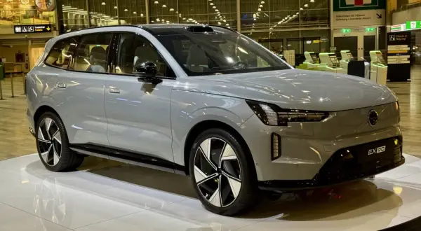 Grå Volvo EX90 på en utställningsplattform. Framtiden för volvo car mobility visas upp på flygplatsen.