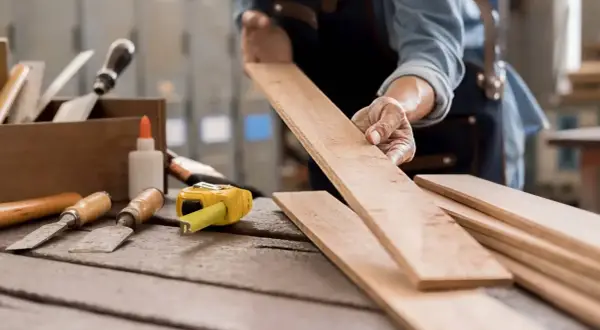 Manos expertas preparan madera para restaurar. Aprende como quitar pintura de la madera sin dañarla con estas herramientas.
