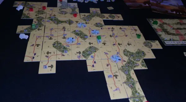 Plansza do gry Carcassonne: Safari. Rozłożone kafelki tworzą mapę sawanny z drogami i zwierzętami.