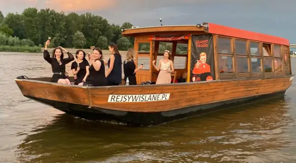 Grupa kobiet świętuje na łodzi przy dworcu wodnym WWA. Zachód słońca nad Wisłą.