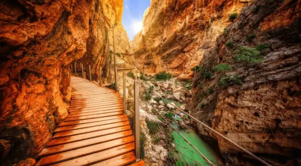 Chemin de bois longeant une gorge spectaculaire en Espagne, avec une rivière émeraude en contrebas. Un trek inoubliable.